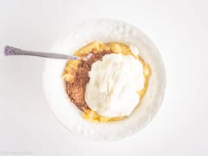 Cocoa, yogurt and banana mixed together in a bowl.