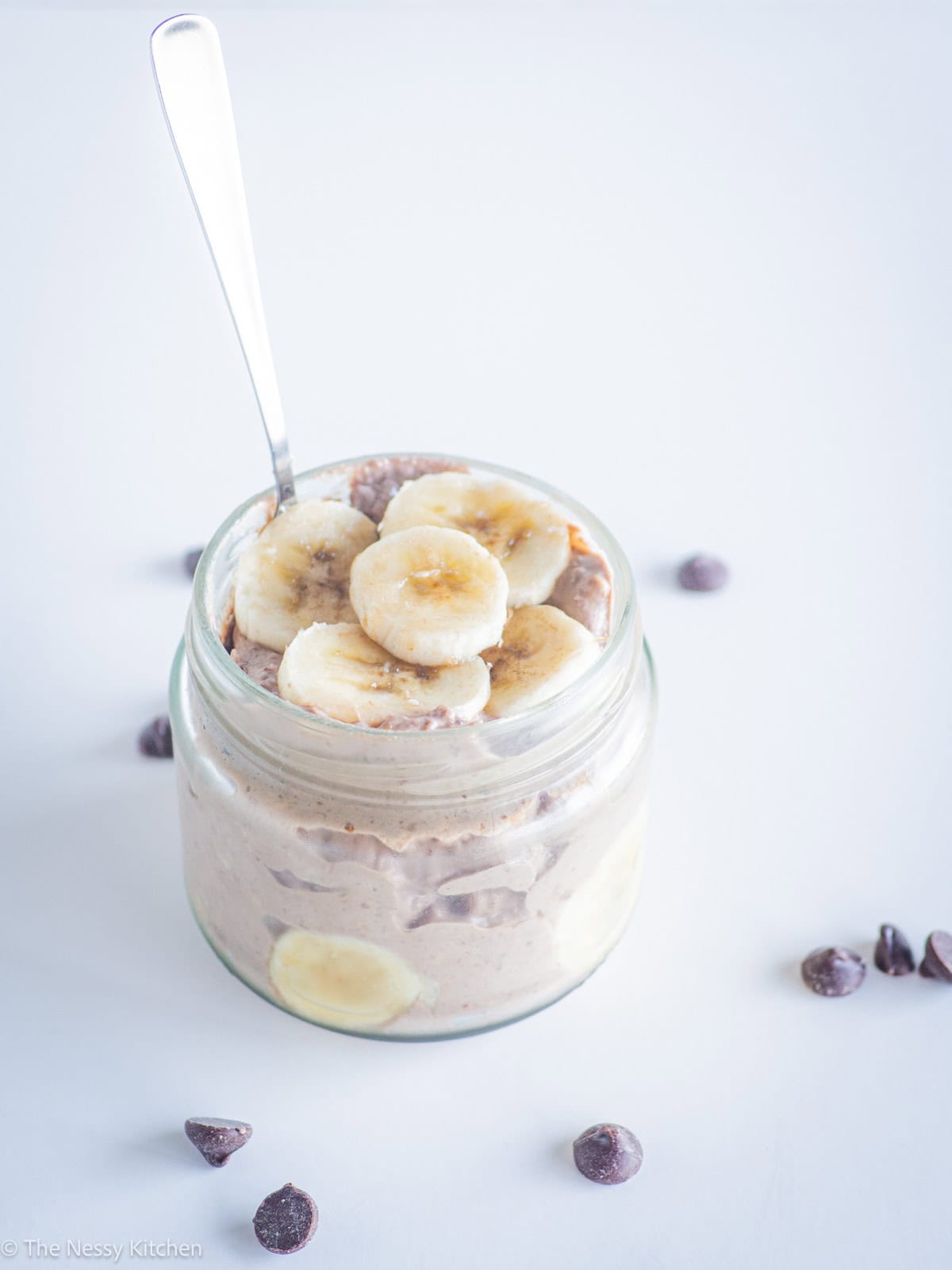 Spoon in a jar of chocolate banana overnight oatmeal.