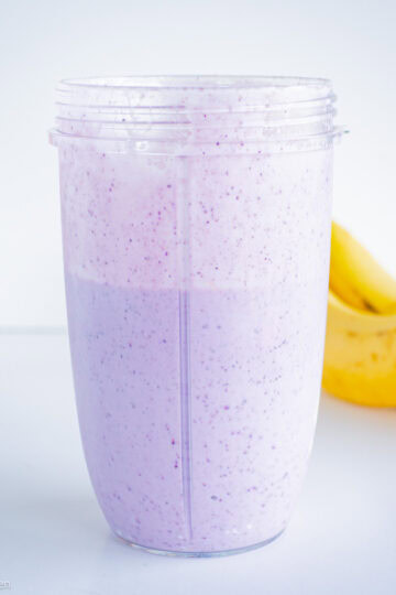 Blueberry banana smoothie in a blender cup.