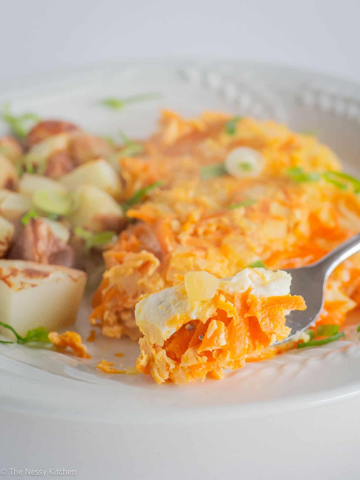 Fork taking a bite out of an omelet.