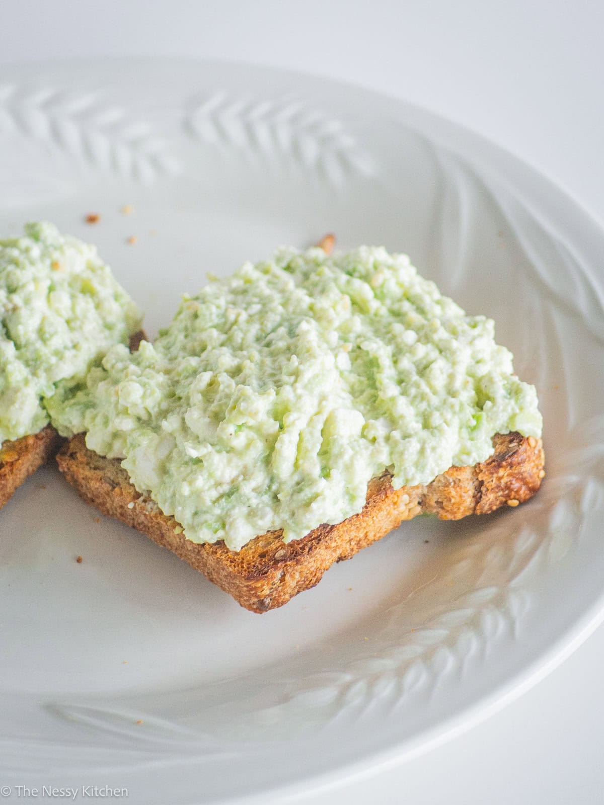 Avocado cottage cheese toast on a plate.
