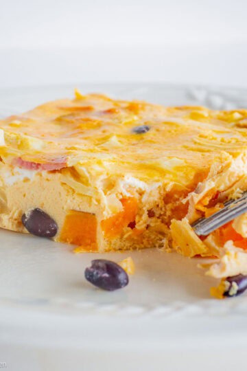 Breakfast casserole on a plate with a fork.