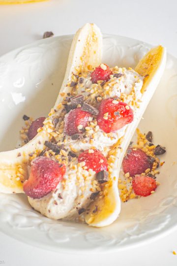 Banana sliced in half and topped with yogurt.