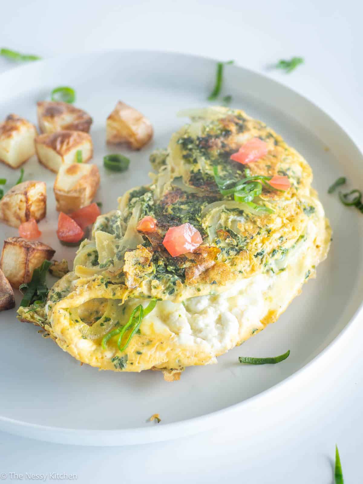 Potatoes and omelet on a plate.