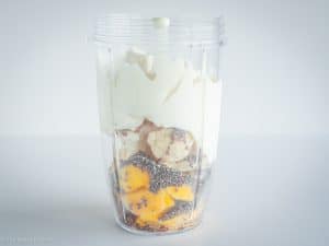 Ingredients layered in a blender.