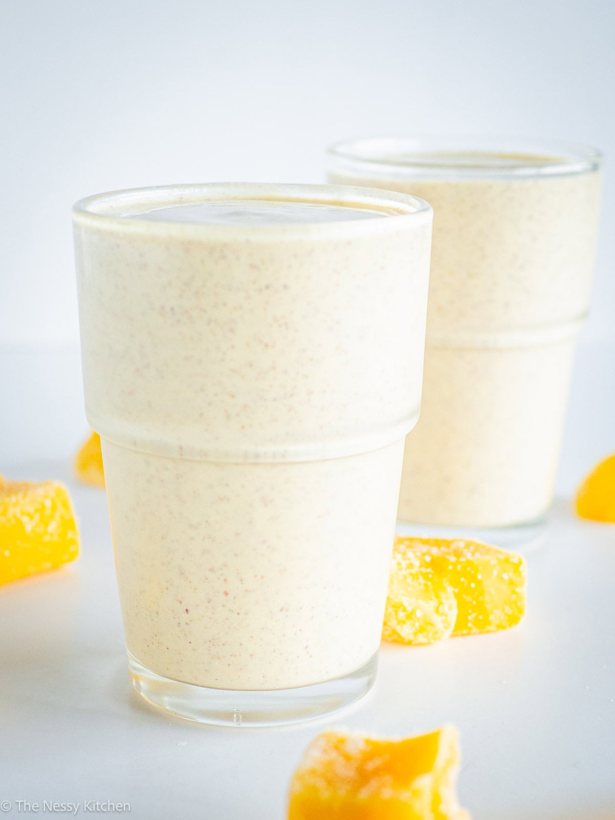 Two glasses with an orange drink.