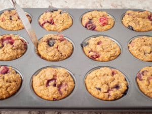 Cooked muffins in tin lifted.