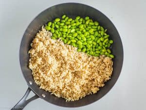 Rice and edamame in pan.
