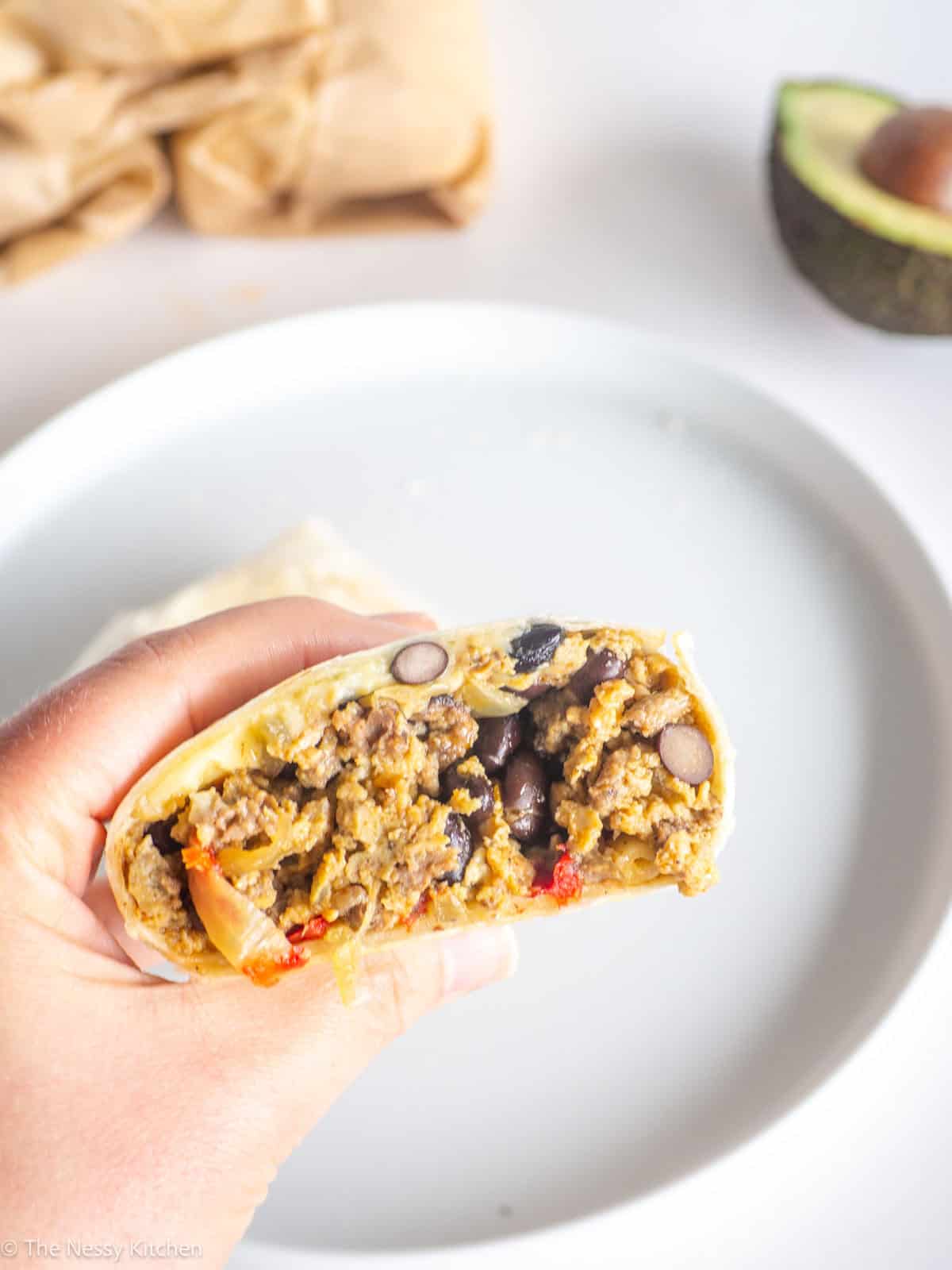 Breakfast burrito in hand.