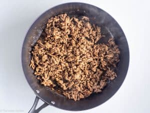 Cooking ground beef and spices in pan.