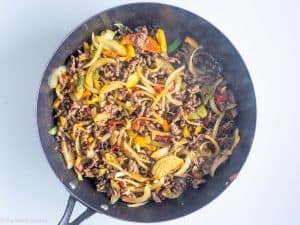Peppers and onions added to pan with ground beef.