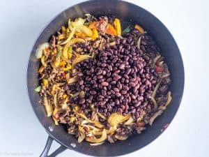 Black beans added to pan.