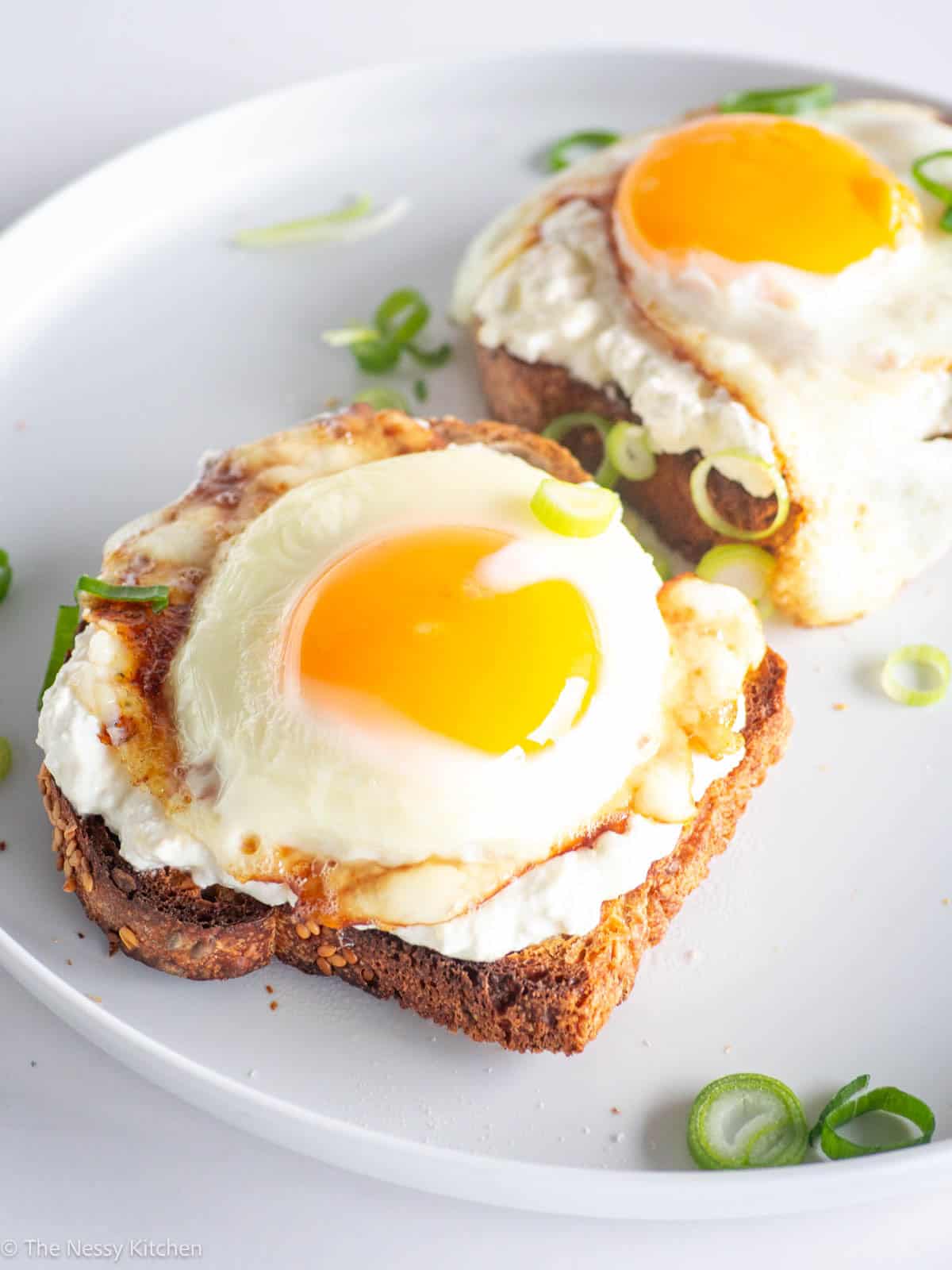 Cottage cheese toasts with eggs on plate.