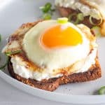 Cottage cheese toast with egg on plate.