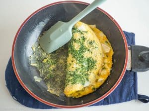 Folded omelet in pan.