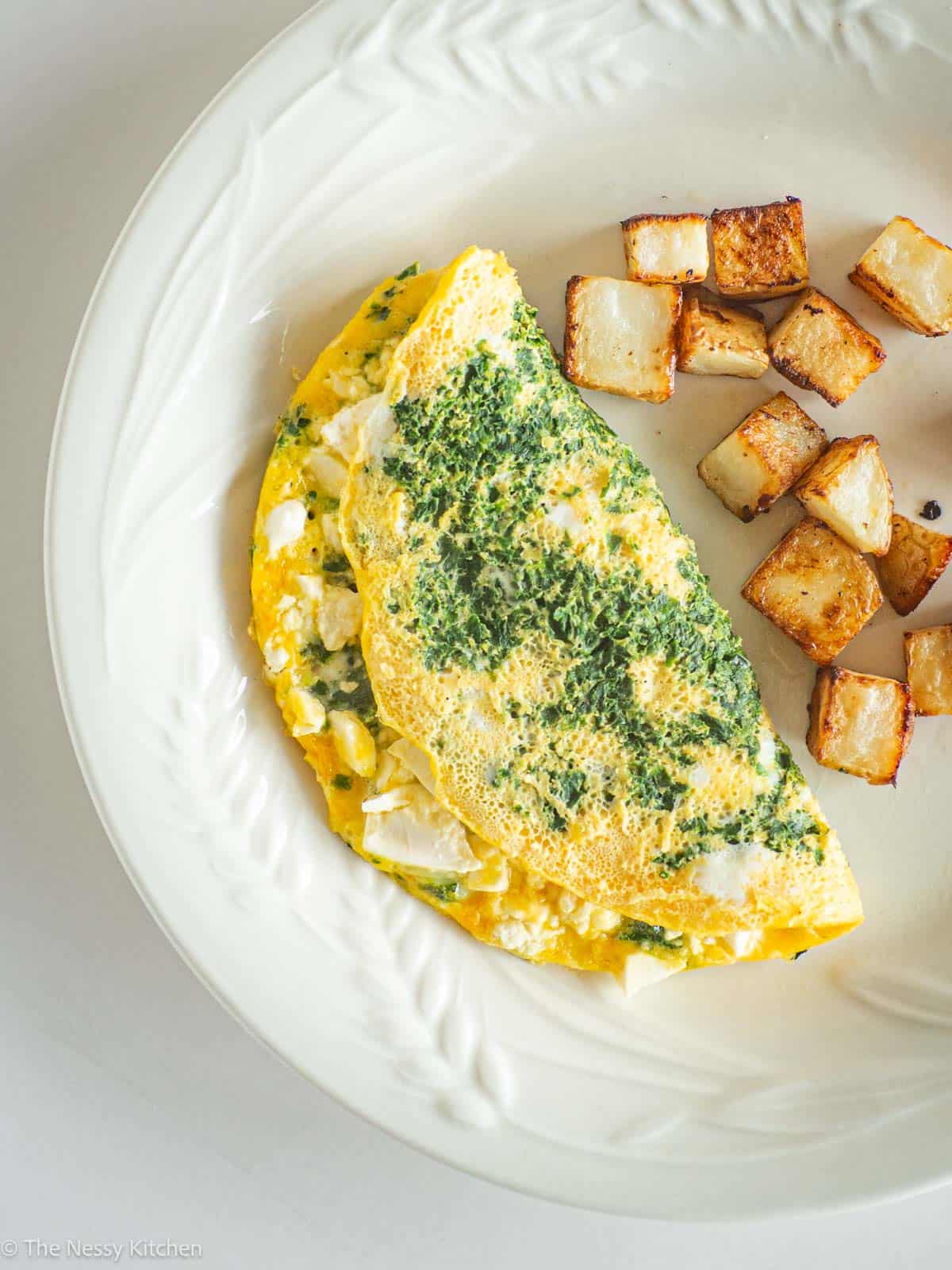 Omelet and potatoes on plate.