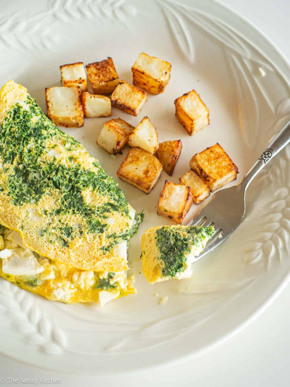 Omelet and potatoes with fork.
