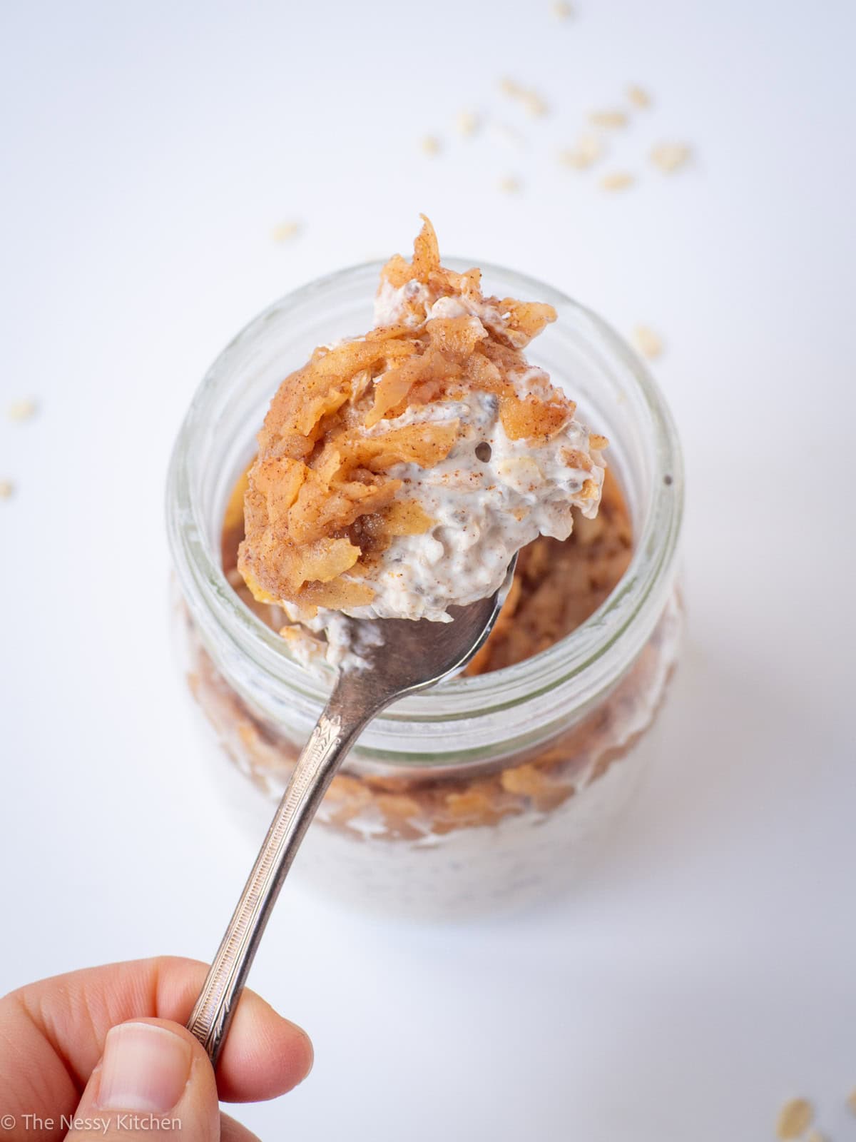 Spoon taking a scoop from a jar of oats.