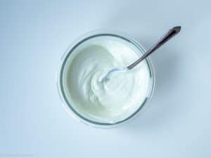 Greek yogurt, honey, and salt in a glass jar with spoon.