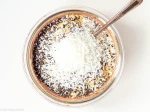Oats, coconut and chia added to a bowl.