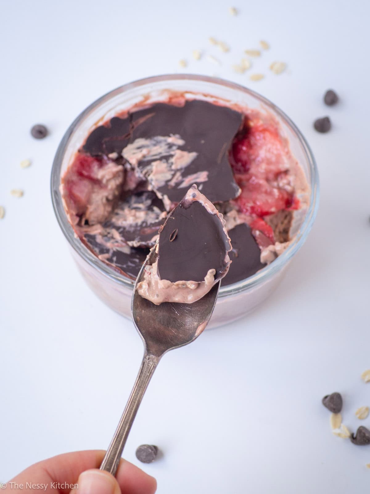 Spoon with a scoop of chocolate strawberry oats.