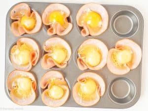 Eggs cracked into ham slices.