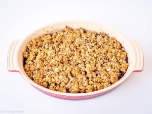 Crumble topping placed over berry filling.