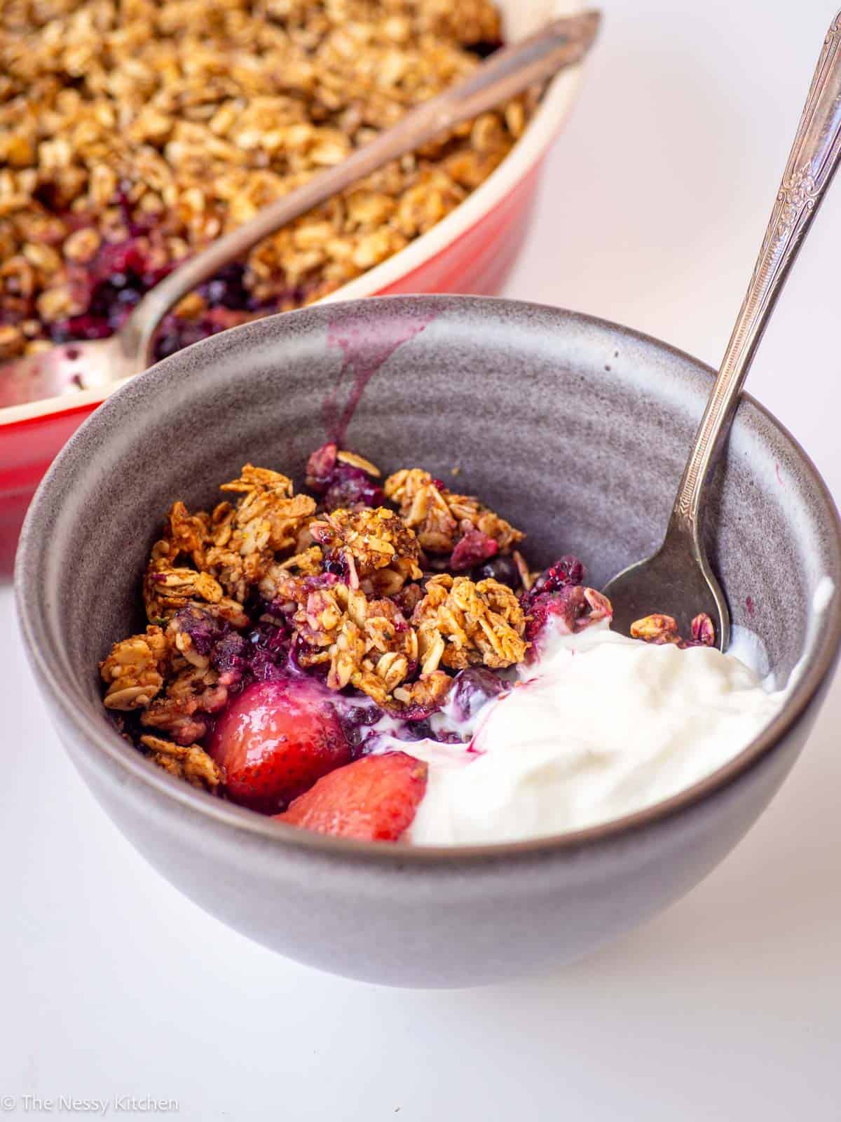 Bowl of breakfast berry crisp with yogurt.