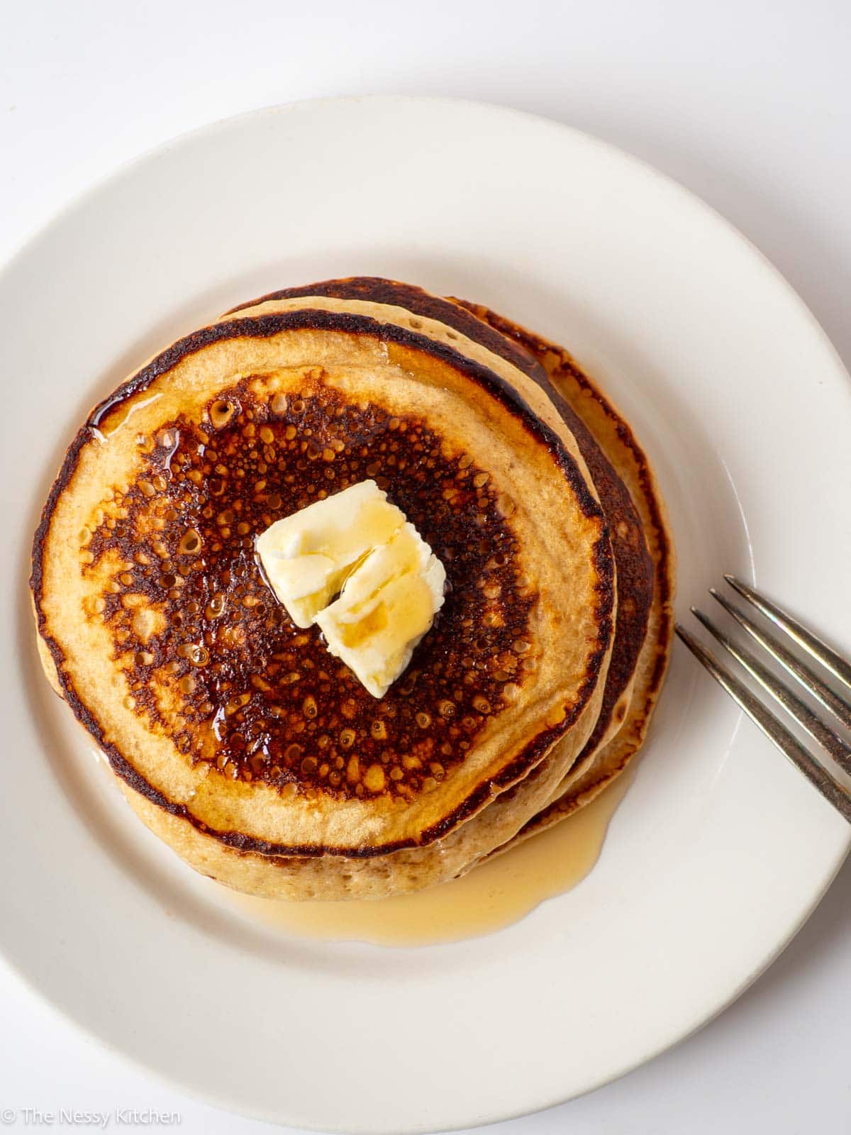 Pancakes topped with butter and maple syrup.