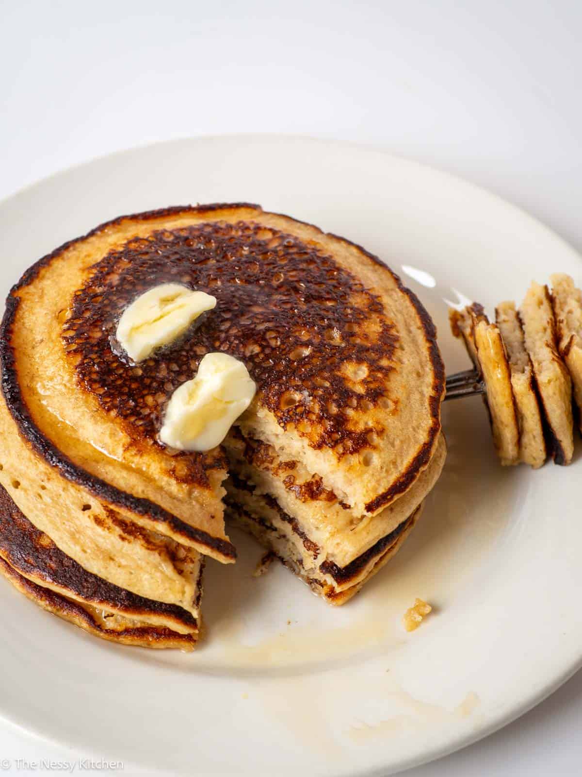 Stack of pancakes with a bite taken out.