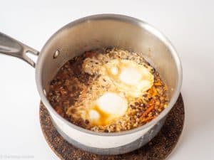 Eggs poached in a pot of lentils.