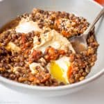 Eggs and lentils in a bowl with a spoon.
