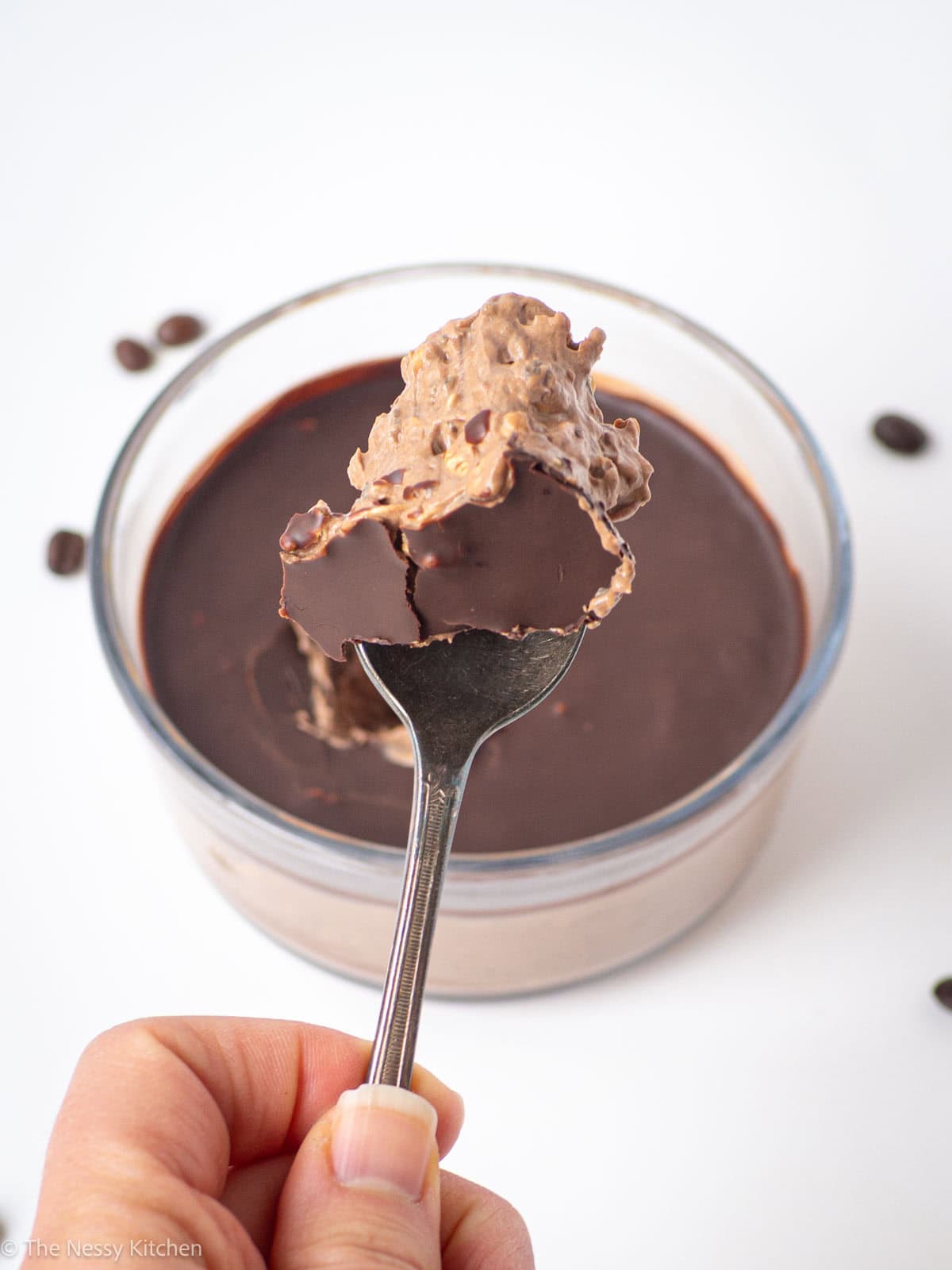 Hand holding a spoon with oatmeal.