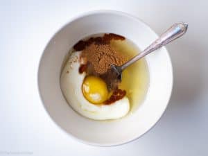 Eggs and egg whites in a bowl with maple syrup and cinnamon.