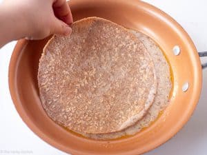 Omelet mixture added to a skillet along with a tortilla.