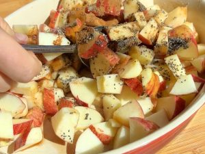 Apples mixed in a baking dish.