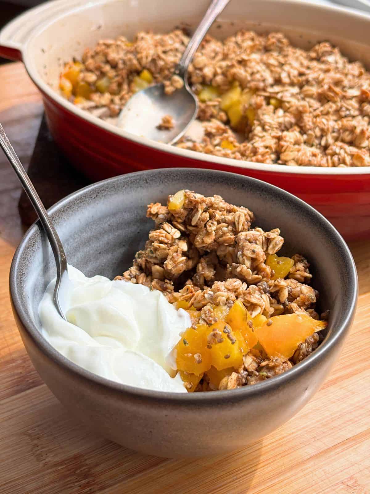 Peach crisp in a dish with yogurt.