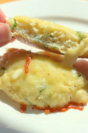 Breakfast biscuit sliced in half and topped with butter.