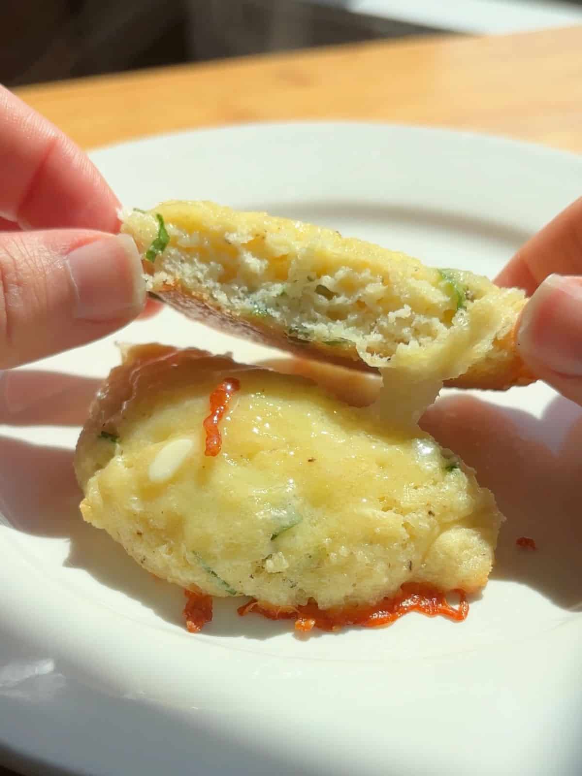 Hand holding a sliced breakfast biscuit.