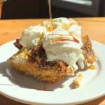 Pumpkin French toast casserole topped with whipped cream and maple syrup.